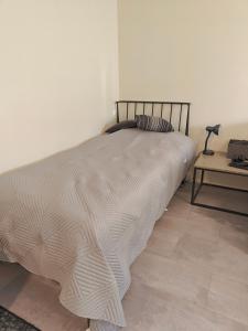 una camera da letto con un letto e un tavolo con una lampada di Eerikinkadun Helmi a Salo