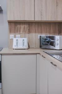 a kitchen counter with a microwave and a toaster oven at Peterhead Pad - SJA Stays - Modern 2 Bed Apartment in Peterhead