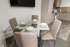 a dining room table with chairs and a television at Peterhead Pad - SJA Stays - Modern 2 Bed Apartment in Peterhead +39 photos