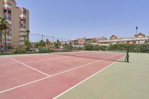 a tennis court with a net and buildings in the background at Calm Bungalow in Torrox