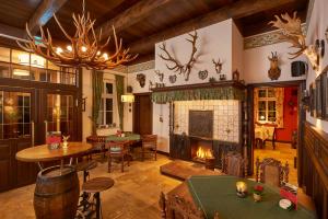 a living room with a fireplace and a table and chairs at Hotel Anno 1848 in Lindern