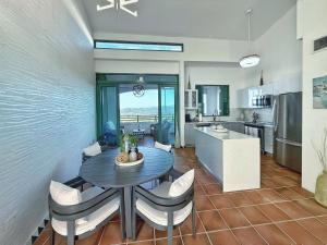 a kitchen and dining room with a table and chairs at Luxury Ocean View Penthouse in Rio Grande