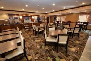 a dining room with tables and chairs in a restaurant at Holiday Inn Express Hotel & Suites Grand Forks by IHG in Grand Forks