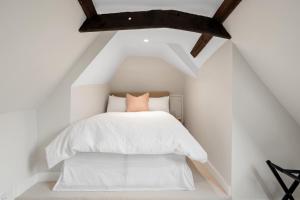 a bedroom with a white bed in a attic at Rayne Road in Braintree