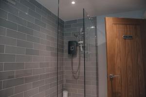 a shower in a bathroom with a glass door at Riverbank Cottage in Ironbridge +12 photos