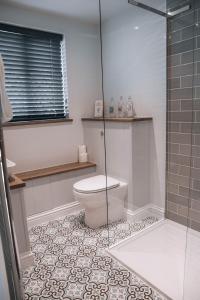a bathroom with a toilet and a glass shower at Riverbank Cottage in Ironbridge +13 photos