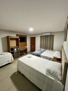a hotel room with two beds and a television at Hotel Pepita in Itaituba +15 photos