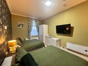een hotelkamer met twee bedden en een flatscreen-tv bij The Holmlea in Blackpool