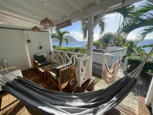 a hammock on the porch of a house at La p’tite barque Antillaise in Deshaies