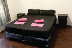 a bed with pink and black sheets and pink paper at Piso García in Mendoza