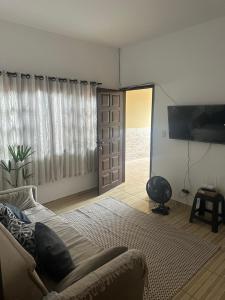 a living room with a couch and a sliding door at Casa Itanhaém Multicultural in Itanhaém