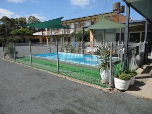 a fence in front of a swimming pool at Cobb Inlander Motel in Hay