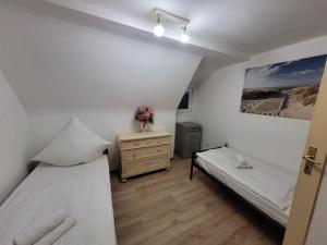 a small room with two beds and a dresser in it at Haus für bis zu 8 Personen in Wachendorf in Cadolzburg +3 photos