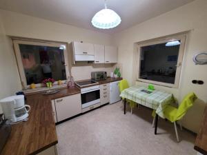 a kitchen with white cabinets and a table with yellow chairs at Haus für bis zu 8 Personen in Wachendorf in Cadolzburg