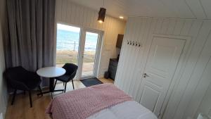 华姆斯唐吉Sauðá Guesthouse的一间卧室，里面有一张床、一张桌子和一扇窗户