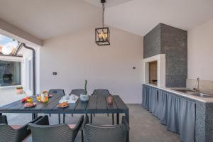 a dining room with a table and chairs and a kitchen at Ferienhaus Nana in Marčana