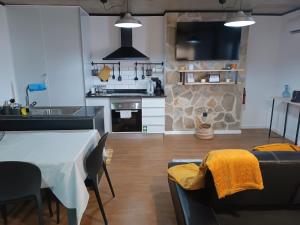 a kitchen and living room with a table and a stove at Kings B&B Eiras in Caniço