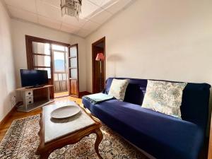 a living room with a blue couch and a table at Apartamento La Magdalena Selnatur in Llanes