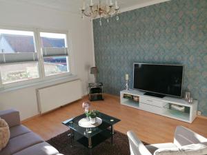 a living room with a tv and a couch and a table at Ferienwohnung Im Wachturm in Tangermünde