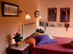 a bedroom with a bed with a red blanket and a table at Gîte El Conejo in Alájar
