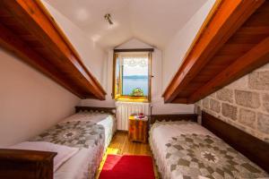 two beds in a small room with a window at Estate in Podgora