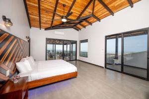 a bedroom with a bed and large windows at Villa cielo y mar azul in Cuajiniquil +14 photos