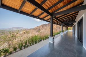 a view from the porch of a house with a wooden roof at Villa cielo y mar azul in Cuajiniquil