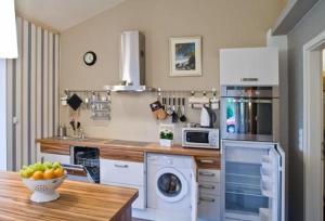 a kitchen with a washer and dryer and a table at Apartment Teichblick Mit Eigener Terrasse in Klein Meckelsen