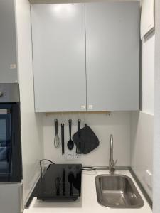 a kitchen with white cabinets and a sink at Über den Dächern von Offenbach in Offenbach