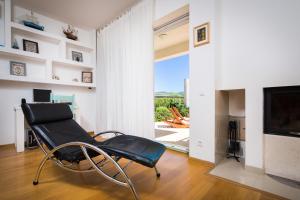 a black chair in a living room with a television at Ferienhaus In Dugopolje Mit Beheiztem Pool in Dugopolje