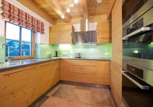 a kitchen with wooden cabinets and a sink at Ferienhaus Wallegg Lodge In Saalbach Hinterglemm in Saalbach Hinterglemm +7 photos