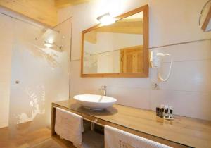 a bathroom with a sink and a mirror on a counter at Ferienhaus Wallegg Lodge In Saalbach Hinterglemm in Saalbach Hinterglemm