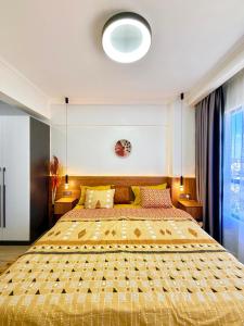a bedroom with a large bed with a yellow comforter at Appartement Marina Bay A13 in Nairobi