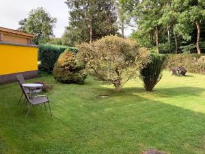 ein Tisch und Stühle in einem Hof mit einem Baum in der Unterkunft Appartement in Nordhausen mit Terrasse, Garten und Grill in Nordhausen + 2 Fotos