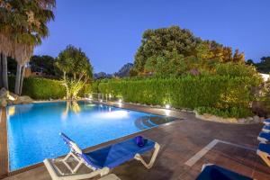 - une piscine avec 2 chaises longues dans la cour dans l'établissement Formosa, à Cala Sant Vicenç