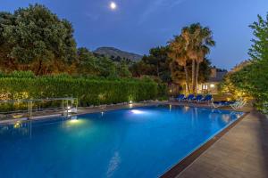 une piscine la nuit avec des chaises et des arbres dans l'établissement Formosa, à Cala Sant Vicenç