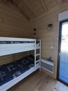 a room with two bunk beds in a cabin at Résidence Copropriété De La Plage - 107 - Invitation au repos dans ce chalet en bois MAE-4471 in Le Verdon-sur-Mer