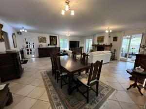 ein Wohnzimmer mit einem Holztisch und Stühlen in der Unterkunft Résidence 104-grayan Et L Hopital - 104 - Agréable villa avec piscine dans un quartier calme MAE-6111 in Grayan-et-lʼHôpital