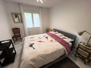 ein Schlafzimmer mit einem Bett mit einer Decke darauf in der Unterkunft Résidence 104-grayan Et L Hopital - 104 - Agréable villa avec piscine dans un quartier calme MAE-6111 in Grayan-et-lʼHôpital