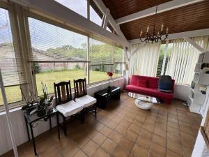 ein Wohnzimmer mit einem roten Sofa und Stühlen in der Unterkunft Résidence 104-grayan Et L Hopital - 104 - Agréable villa avec piscine dans un quartier calme MAE-6111 in Grayan-et-lʼHôpital