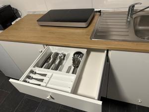 a kitchen counter with an open drawer with utensils at Helle und moderne 2 Zimmerwohnung in Mönchengladbach-Zentrum in Mönchengladbach +32 photos