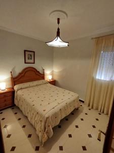 a bedroom with a large bed and a window at Merino Casa Rural in Yunquera