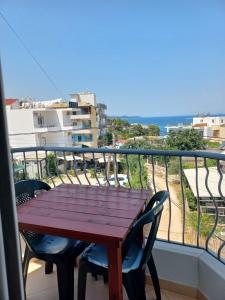 a wooden table on a balcony with a view of the ocean at Vila Ester in Ksamil