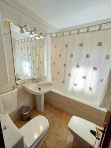 a bathroom with a sink and a toilet and a tub at Merino Casa Rural in Yunquera