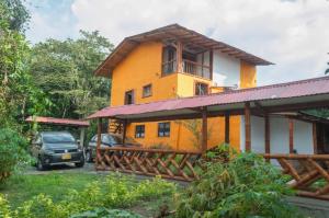 a house with a car parked in front of it at Apto/cabaña naranja in Ulloa
