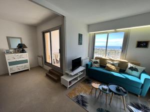 un soggiorno con un divano blu e una TV di Résidence Marine - 064 - Appartement entièrement rénové et décoré avec goût MAE-6921 a Soulac-sur-Mer