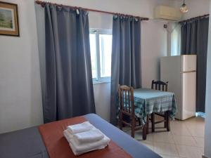 a room with a bed and a table and a kitchen at Vila Ester in Ksamil