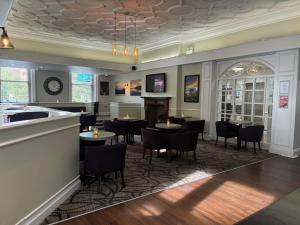 a restaurant with tables and chairs and a clock on the ceiling at Carlisle Station Hotel, Sure Hotel Collection by BW in Carlisle