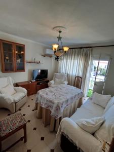 a room with two beds and a table and a tv at Merino Casa Rural in Yunquera
