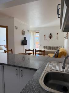 Una cocina con fregadero y una sala de estar. en Sesimbra Village T1, en Sesimbra 13 fotos más